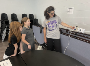 Students learning how a power strip saves energy.